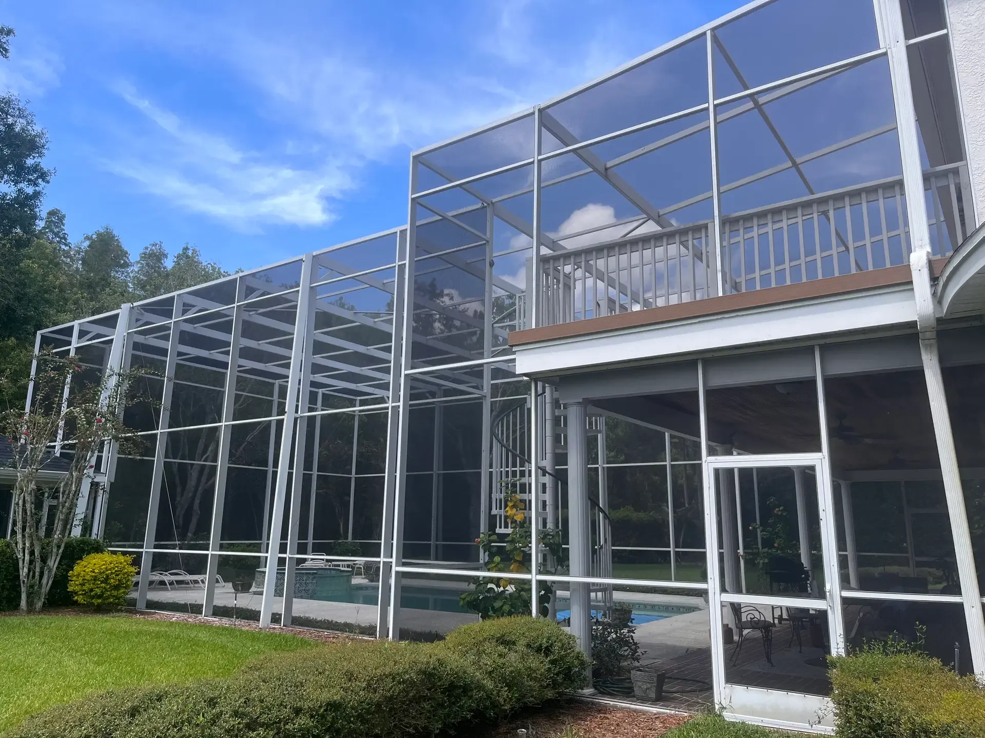 Pool enclosure with an elevated screened porch attached to a home; additional Lily Luxe Rescreen project photo.