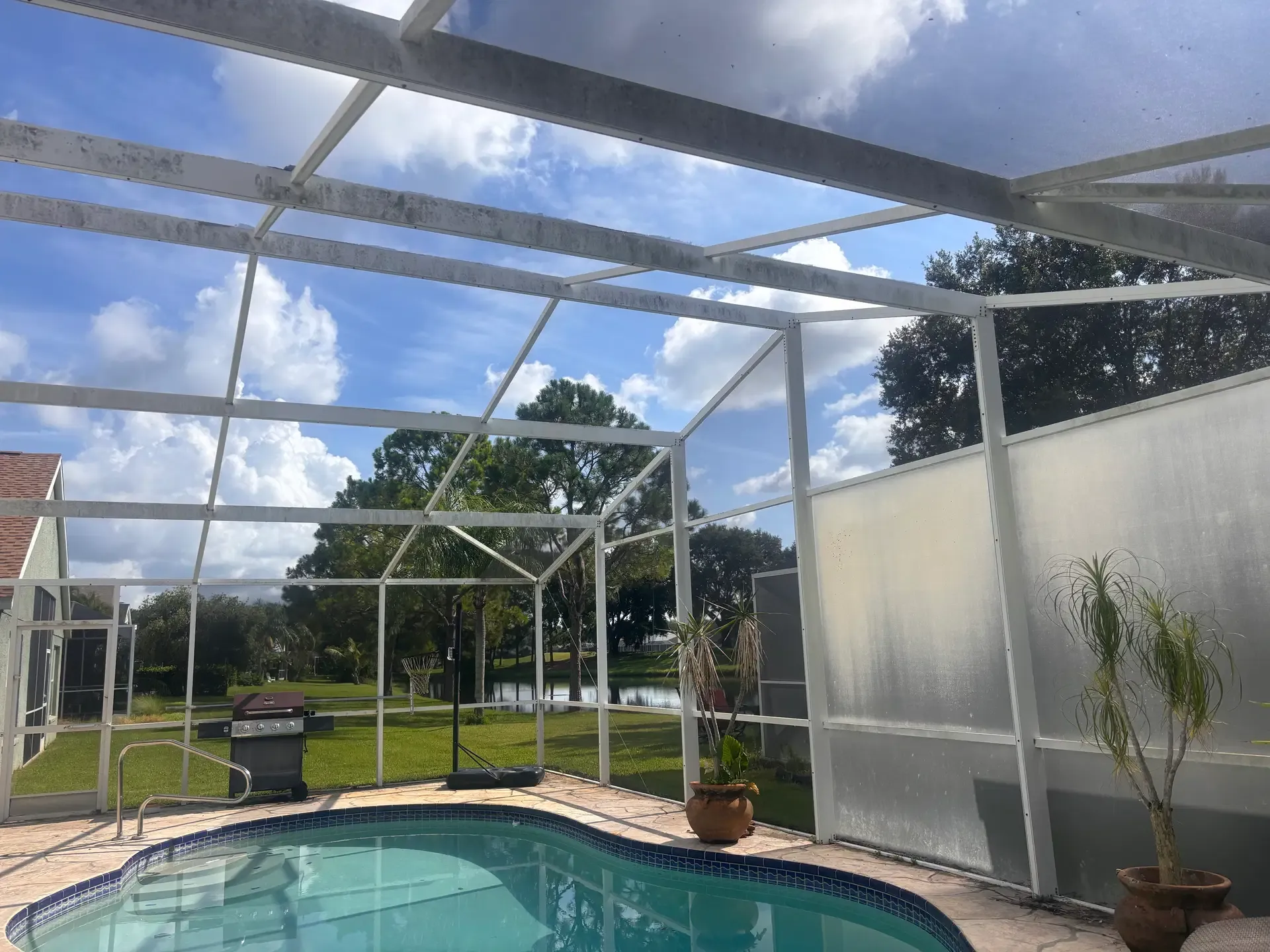Cheval pool enclosure before restoration, with light aluminum frame and existing screen panels.